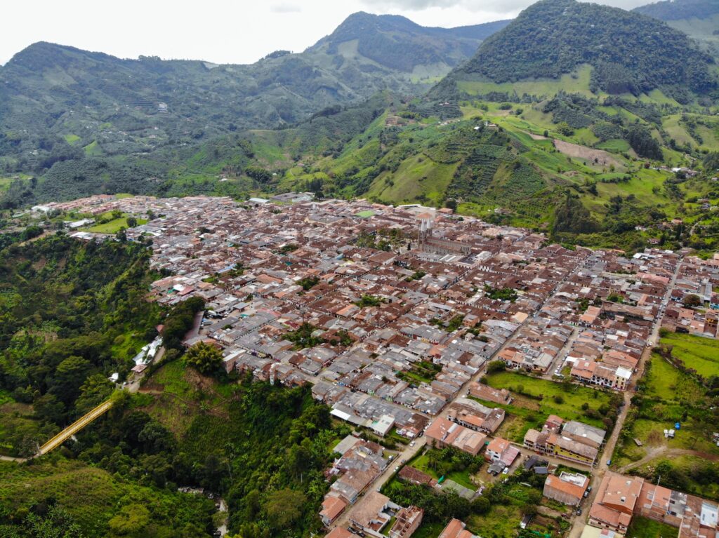 Houses Surrounded by Green Mountains, Trees and Plants